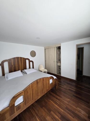 a bedroom with a wooden bed and wooden floors at Lindo apto cerca a todo! in Sabaneta