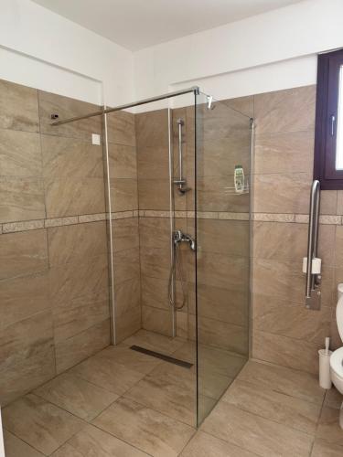 a shower with a glass door in a bathroom at Daniel's Hotel Apartments in Paphos