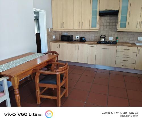 a kitchen with a wooden table and wooden chairs at Firehouse self-catering unit 6 in Wellington