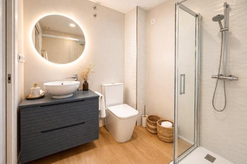 a bathroom with a sink and a toilet and a mirror at Casa Cuca O Grove in O Grove
