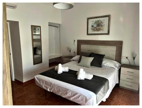 a bedroom with a large bed with white towels on it at Casa Veracruz in Alora