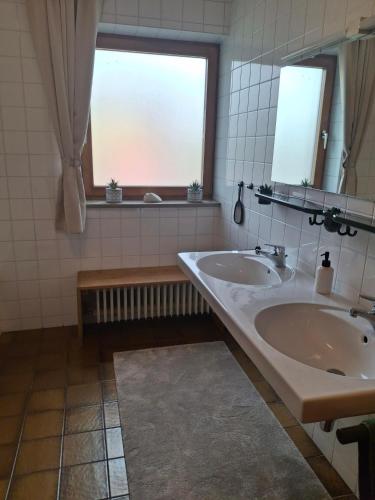 a bathroom with two sinks and a window at Ferienwohnung Theresia in Laufen