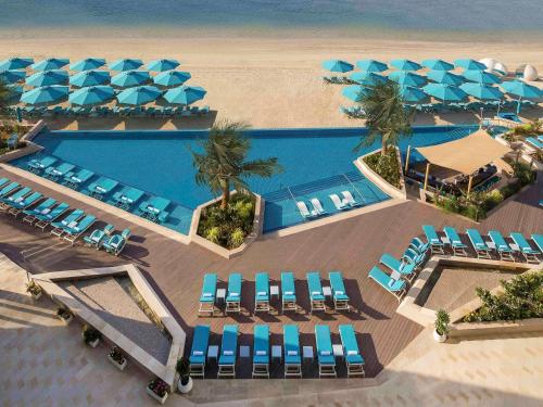 an aerial view of a resort with a pool and chairs at The Retreat Palm Dubai MGallery by Sofitel in Dubai