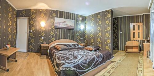 a bedroom with a bed in a room with wallpaper at Discret Hotel & Restaurant in Vladaya