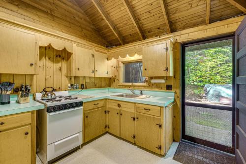 a kitchen with wooden cabinets and a stove top oven at Rustic Cabin w/ Squam Lake Access & Fireplace! in Holderness