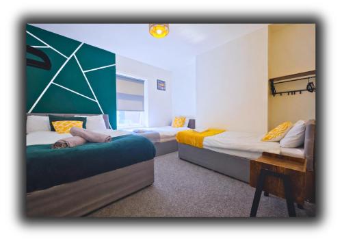 a room with two beds and a table in it at Pitchside Quarters Near Anfield sleeps 7 in Liverpool