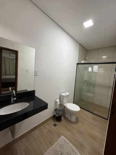 a bathroom with a toilet and a sink and a shower at Chácara Vittorino in Artur Nogueira