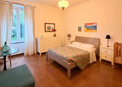 a bedroom with a bed and a table and window at Terrazza Le Grazie in Le Grazie