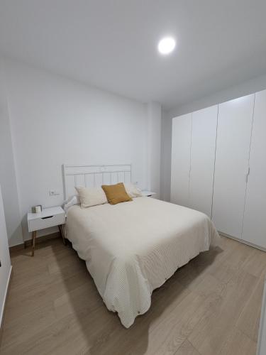 a white bedroom with a bed and white cabinets at Apartamento Calle Bolsa in Sanlúcar de Barrameda