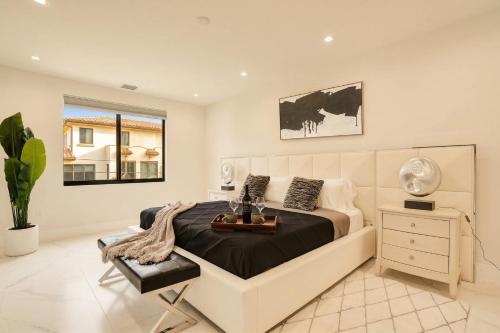 a bedroom with a bed and a desk and a window at Luxury Paradise walk to Las Olas -5 mins to Beach in Fort Lauderdale