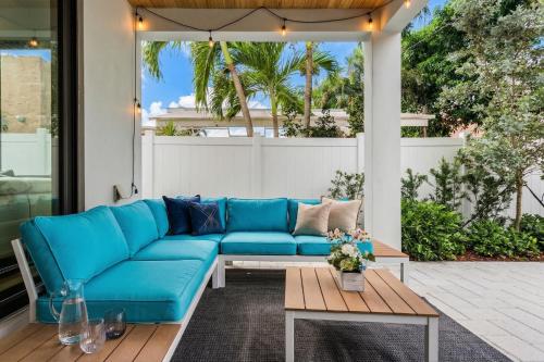 a blue couch on a patio with a table at Luxury Paradise walk to Las Olas -5 mins to Beach in Fort Lauderdale