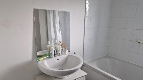 a white bathroom with a sink and a bath tub at Amani Sanctuary 2 Bedroom House in Sherburn Hill