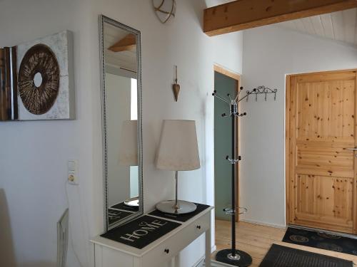 a room with a mirror and a lamp on a dresser at Landhotel Eisdorf in Eisdorf
