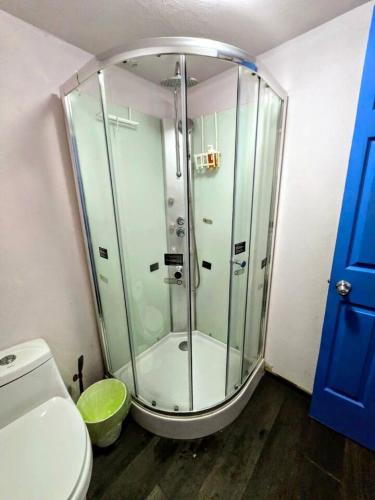 a glass shower in a bathroom with a toilet at Suite Azul 3 personas comoda y equipada in Mexico City