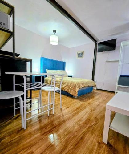 a bedroom with a bed and a table and chairs at Suite Azul 3 personas comoda y equipada in Mexico City