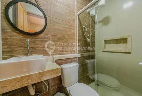 a bathroom with a toilet and a sink and a mirror at Flat Guaramiranga - Apto 202 in Guaramiranga