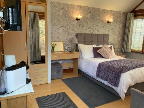 a bedroom with a bed and a desk at Whortleberry Studio B & B in Porlock