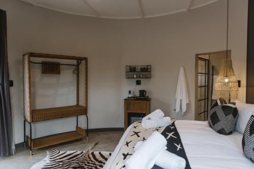 a bedroom with a bed with black and white pillows at The Orpen Kruger, Cork Tree Collection in Welverdiend
