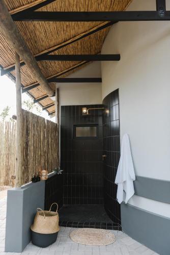 a bathroom with a black tiled shower with a white towel at The Orpen Kruger, Cork Tree Collection in Welverdiend