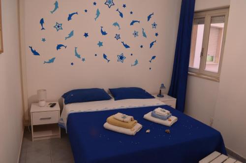 una camera da letto con un letto con uccelli blu sul muro di Vento Di Scirocco a Pozzallo