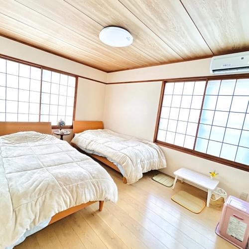 two beds in a room with windows at Makeit 1to3 - Vacation STAY 17354 in Chichibu