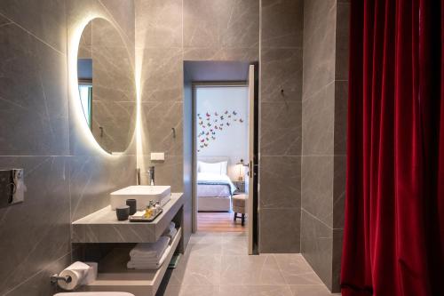 a bathroom with a sink and a red shower curtain at Nine Athens Hotel in Athens