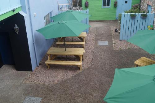 a green umbrella sitting on a set of wooden steps at The Narrows Guesthouse in Portaferry