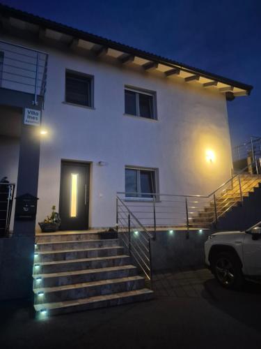 a white house with a staircase in front of it at Apartments Villa Ines Skofije -near Koper in Zgornje Škofije