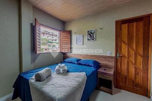 a bedroom with two beds and a wooden door at Flat Guaramiranga - Apto 203 in Guaramiranga