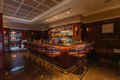 a bar with bar stools in a room at Iroquois New York Times Square in New York