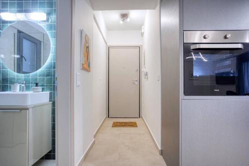 a bathroom with a sink and a door with a mirror at Alba Luxury Suite Trikala in Tríkala