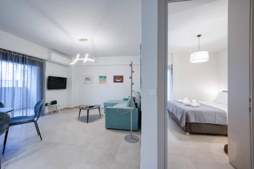 a bedroom and a living room with a bed and a table at Alba Luxury Suite Trikala in Tríkala