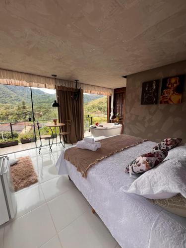 a bedroom with a large bed and a bath tub at Pousada Rio da Prata in Blumenau