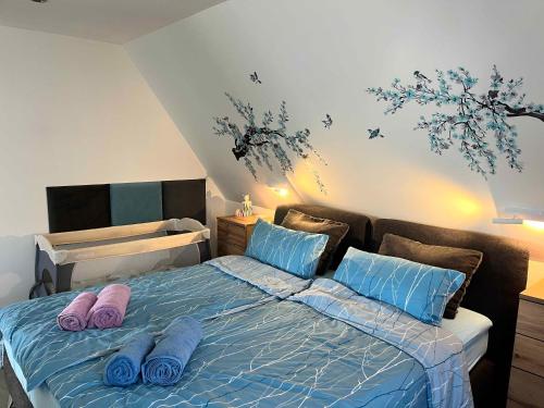a bedroom with a bed with blue sheets and blue pillows at Ferienwohnung bei Rheine Neubau 2026 mit Klima Terrasse ruhige Lage in Neuenkirchen