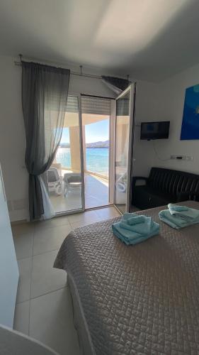 a bedroom with a bed and a view of the ocean at Appartamento Delfino Bianco in Golfo Aranci