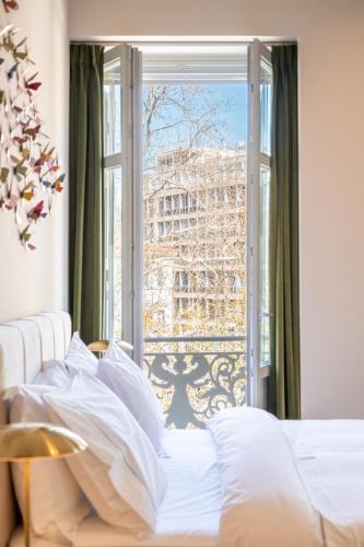 a bed in a bedroom with a view of the eiffel tower at Nine Athens Hotel in Athens