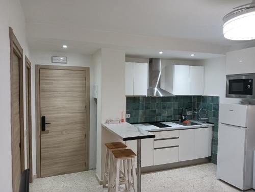 a kitchen with white cabinets and green tile at Ágora House Alcalá de Guadaira 2 in Alcalá de Guadaira