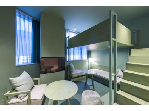a small room with a bed and a table and chairs at toggle hotel suidobashi - Vacation STAY 13465v in Tokyo