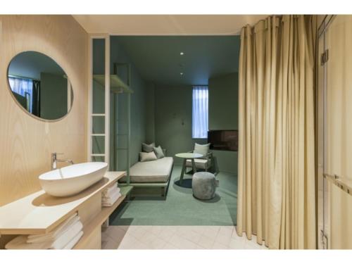 a bathroom with a white sink and a living room at toggle hotel suidobashi - Vacation STAY 13465v in Tokyo