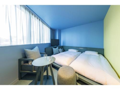 a room with two beds and a table in it at toggle hotel suidobashi - Vacation STAY 18203v in Tokyo