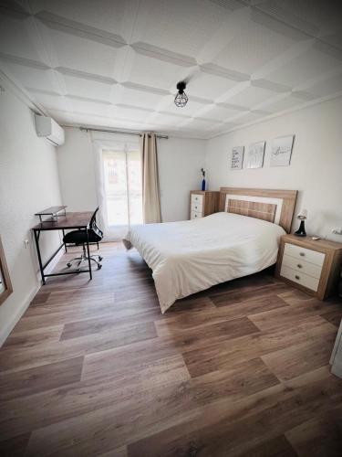 a bedroom with a bed and a desk in it at Casa Sempere in Elche