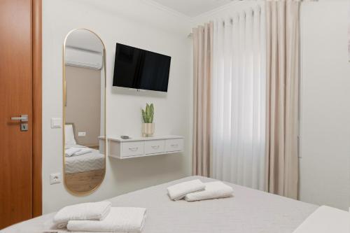 a white room with a bed and a mirror at House Seda in Limenas