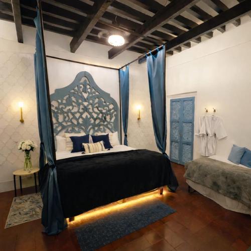 a bedroom with a canopy bed with blue curtains at Casa Fiori San Miguel de Allende in San Miguel de Allende