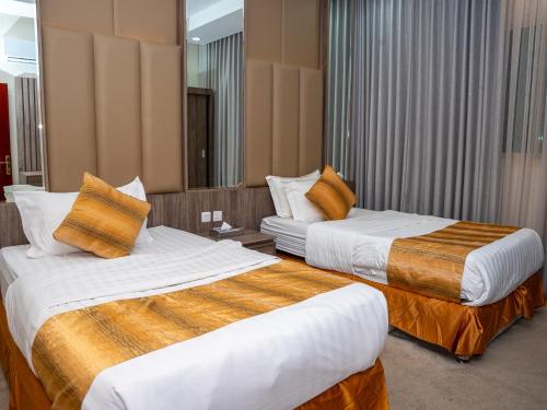 ein Hotelzimmer mit zwei Betten und einem Spiegel in der Unterkunft فندق نخبة الجوي Elite Express Hotels in Riad