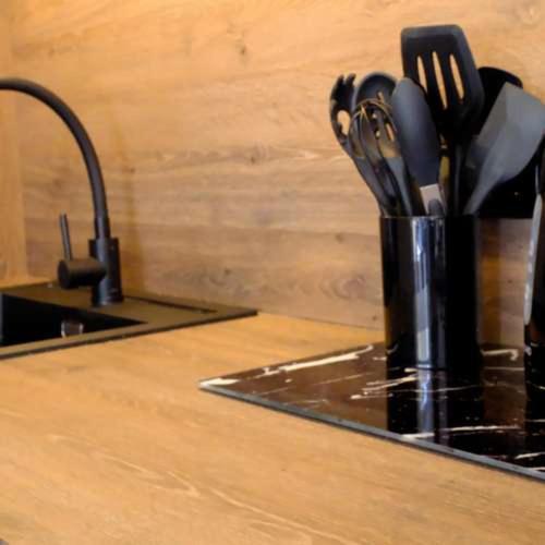 a cup of kitchen utensils on a counter next to a sink at Luxury chalet Stay Smiley with hottub - Includes FREE pool access in Heinkensand