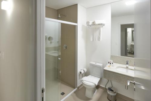 uma casa de banho com um WC, um lavatório e um chuveiro em Ramada by Wyndham Campinas Viracopos em Campinas