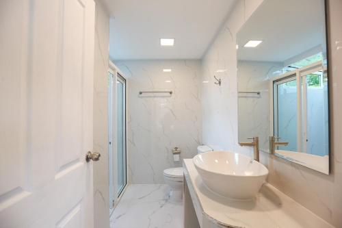 a white bathroom with a sink and a toilet at Little Tree House in Mu Si