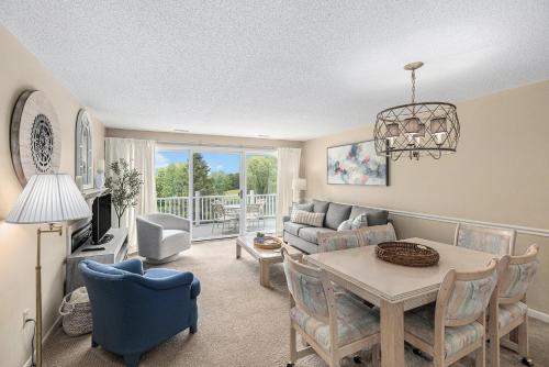a living room with a table and a couch at Beautiful Comfy 2 Bedroom Condo Stunning Golf Course Views 5166 in Traverse City