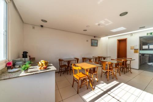 a restaurant with tables and chairs in a room at Minuano Hotel Home próximo ao aeroporto in Porto Alegre