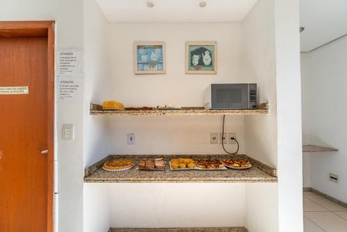 a room with plates of pastries on a counter at Minuano Hotel Home próximo ao aeroporto in Porto Alegre